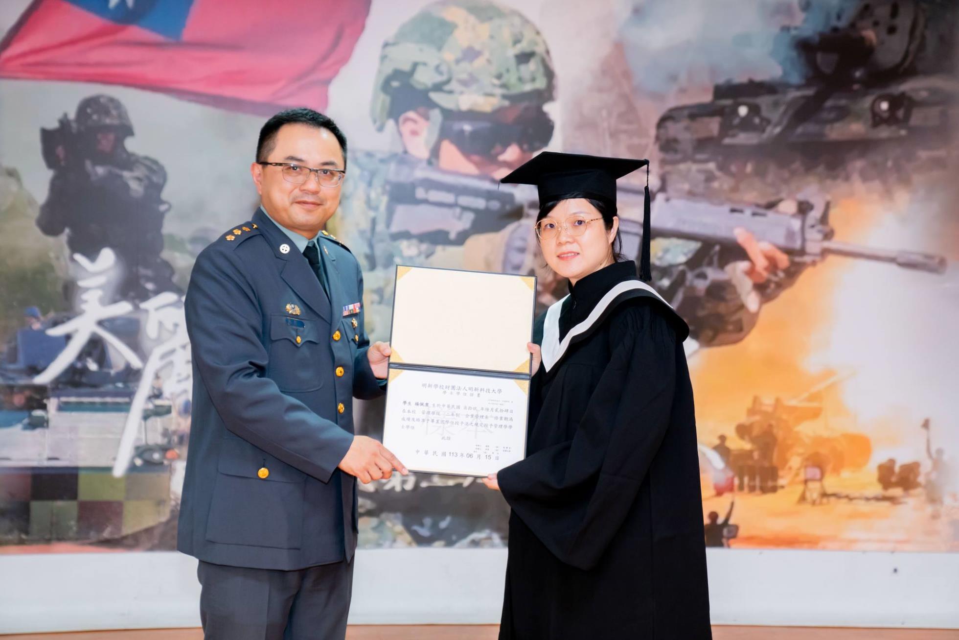 027陸軍269旅副旅長張上校頒發畢業證書予畢業生楊佩潔同學(技企四乙總務)