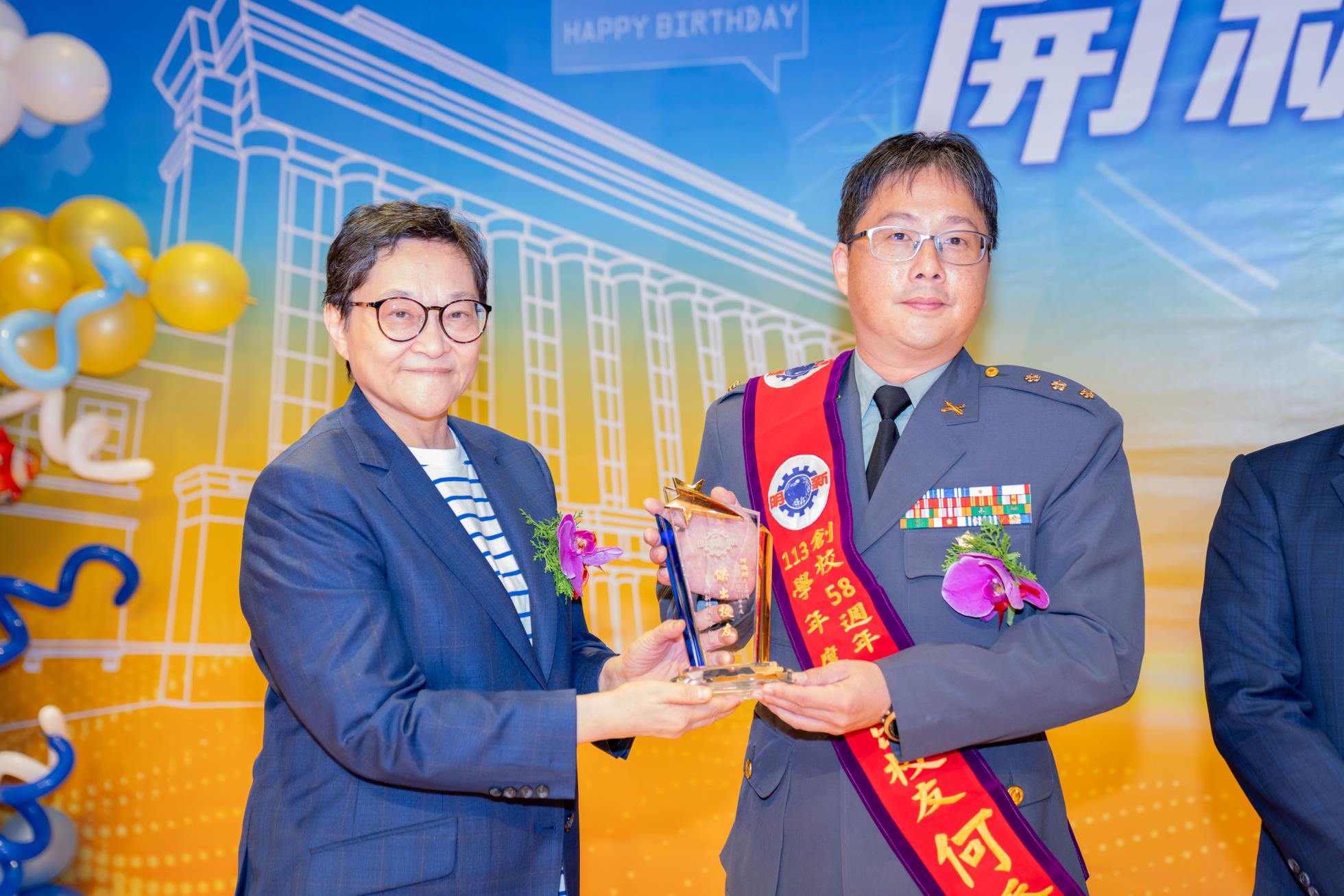 02.新竹後備指揮部何僑軒上校，對於推動國軍後備動員工作貢獻卓著，獲選本校傑出校友，於113年58周年校慶大會中，由董事長郝碧蓮公開表揚